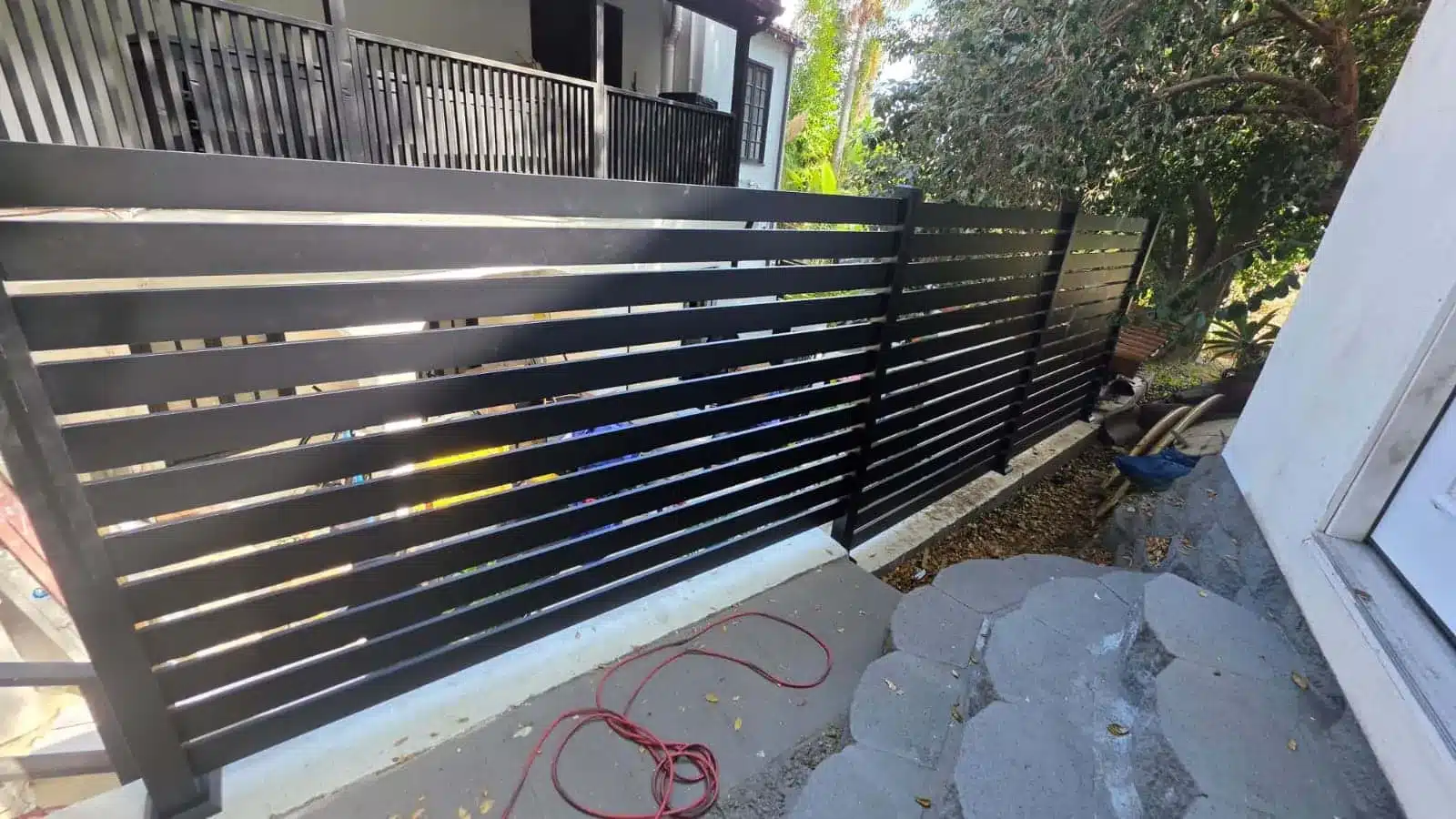 Horizontal aluminum fence stepping down a sloped backyard