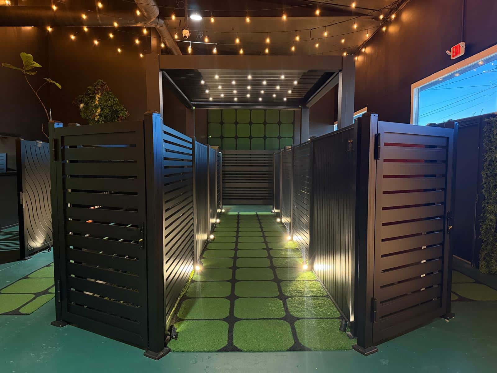 Black aluminum fence panels along a walkway in the Lumina showroom